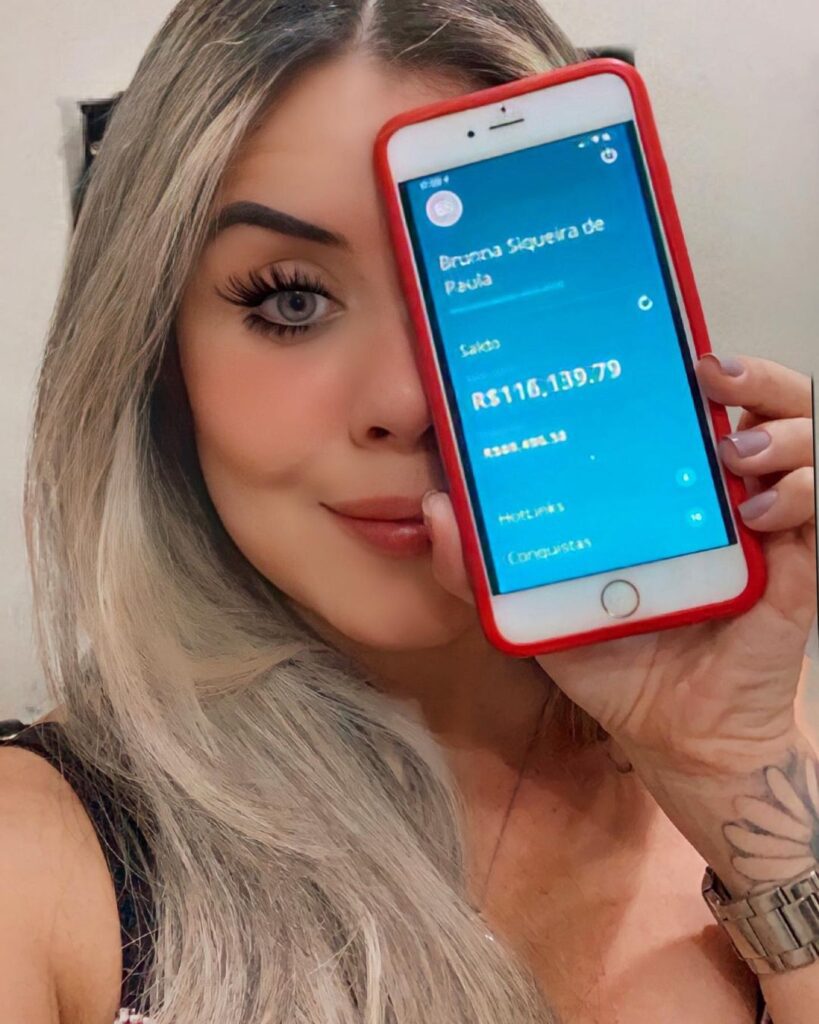 Imagem da Bruna Siqueira com o celular na frente do rosto demonstrando como são os resultados na Hotmart